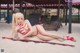 A woman in a red and white striped bikini laying on the sand.