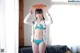 A woman in a bikini holding a pizza on her head.