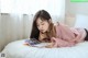 A woman laying on a bed reading a book.