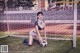 A woman kneeling on the ground with a soccer ball.