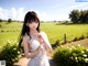 A woman in a white dress standing in a field of flowers.