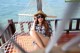 A woman sitting in a hammock on a wooden dock.