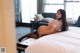 A pregnant woman laying on a bed in a hotel room.