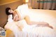 A woman laying on a bed in a hotel room.