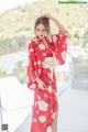 A woman in a red kimono standing on a balcony.